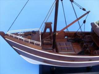 This wooden fishing boat model is attached to a sturdy wooden base
