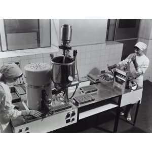  Workers at a Machine Packaging Medicinal Suppositories at 