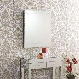 Elegant frameless wall mirror above a mirrored accent table